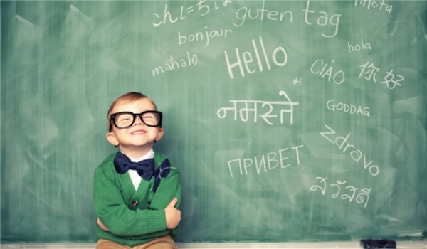 A boy laughing in front of a blackboard 