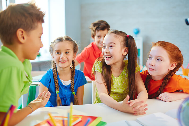 Happy friends talking during break in school